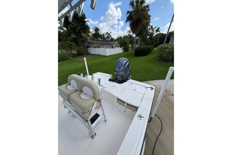 Slide: The Image of 2020 Sea Born FX22 Bay boat with seating and motor, surrounded by lush greenery. - 19