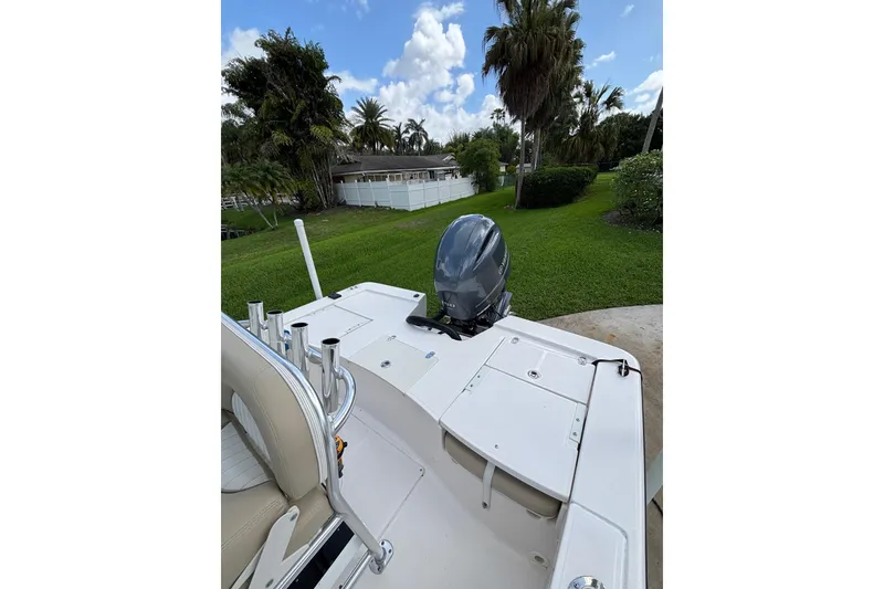 Slide: The Image of 2020 Sea Born FX22 Bay boat with outboard motor, parked on lush green lawn. - 20
