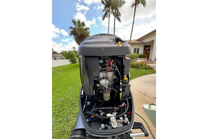 Slide: The Image of 2020 Sea Born FX22 Bay boat engine, open cover, in a residential driveway setting. - 26