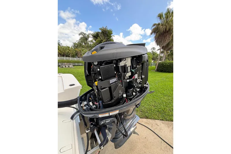 Slide: The Image of 2020 Sea Born FX22 Bay boat engine with open cover, showcasing internal components. - 27