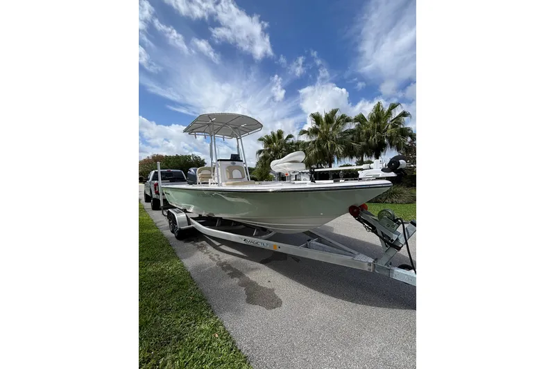 Slide: The Image of 2020 Sea Born FX22 Bay boat on trailer, parked roadside under a partly cloudy sky. - 3