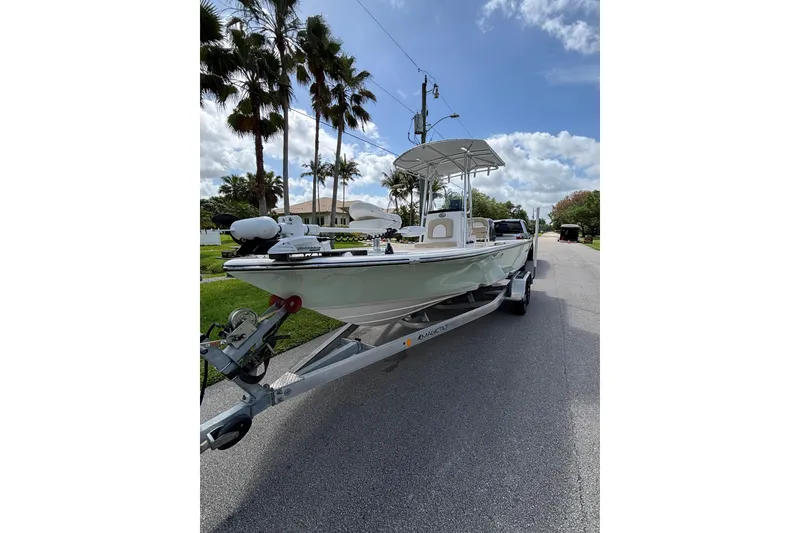 Slide: The Image of 2020 Sea Born FX22 Bay boat on trailer, parked on a sunny street with palm trees. - 4