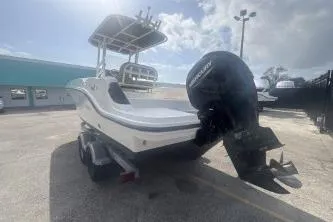 Slide: The Image of 2023 Bayliner Trophy T22CC boat with outboard motor in a sunny marina. - 3