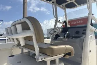 Slide: The Image of 2023 Bayliner Trophy T22CC boat interior with helm and seating under a clear sky. - 9