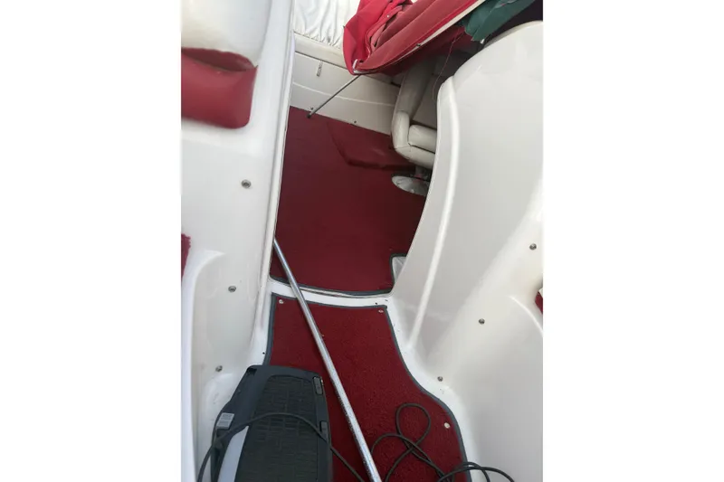 Slide: The Image of Interior of a 1998 Larson Escape Delta-Conic boat with red carpet and white seating. - 13