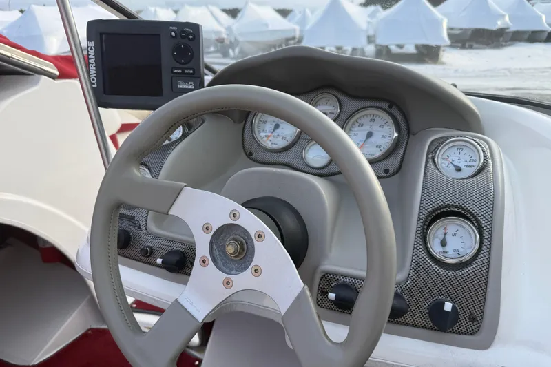 Slide: The Image of Steering wheel and dashboard of a 1998 Larson Escape Delta-Conic boat with gauges and controls. - 15