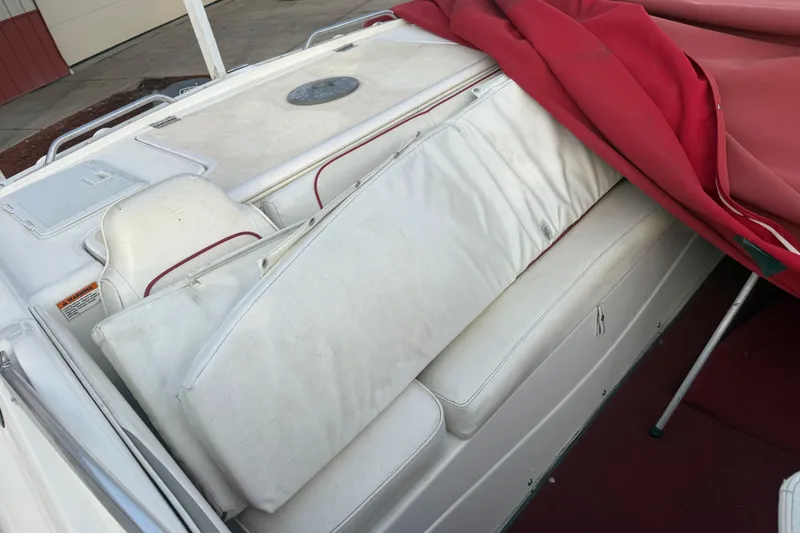 Slide: The Image of 1998 Larson Escape Delta-Conic boat interior with white seating and red cover. - 17