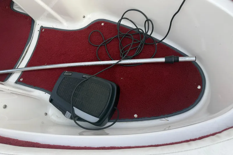 Slide: The Image of Red carpeted interior of a 1998 Larson Escape Delta-Conic boat with equipment. - 18