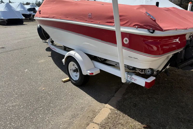 Slide: The Image of 1998 Larson Escape Delta-Conic boat with red cover on trailer in parking lot. - 6