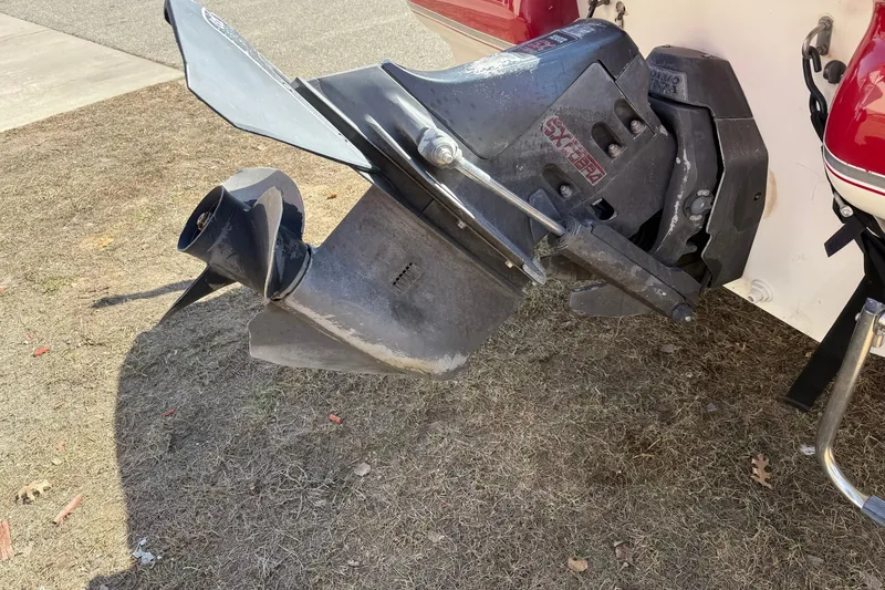Slide: The Image of 1998 Larson Escape Delta-Conic boat motor and propeller on dry grass. - 8