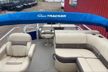 Slide: The Image of 2015 Sun Tracker Fishin' Barge 22 DLX with beige seating and blue canopy. - 4