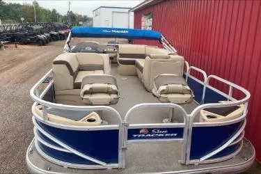 Slide: The Image of 2015 Sun Tracker Fishin' Barge 22 DLX pontoon boat with blue accents and beige seating. - 6