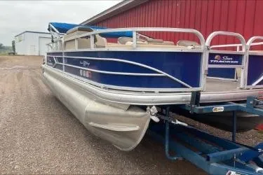 Slide: The Image of 2015 Sun Tracker Fishin' Barge 22 DLX pontoon boat on trailer, parked near red building. - 7