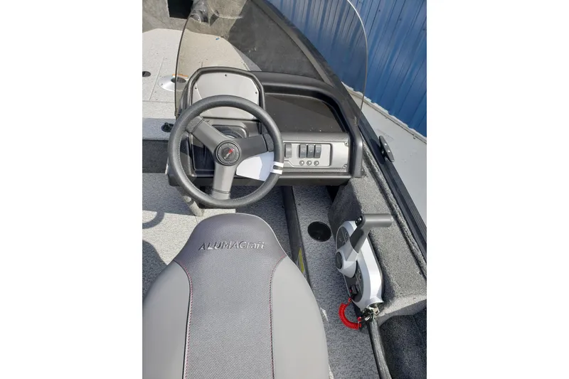 Slide: The Image of 2026 Alumacraft Escape 165 CS boat interior with steering wheel and control panel. - 16