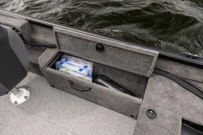 Slide: The Image of 2026 Alumacraft Escape 165 CS boat storage compartment with fishing gear and tackle box. - 22