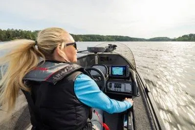 Slide: The Image of Woman steering 2026 Alumacraft Escape 165 CS boat on a scenic lake. - 7