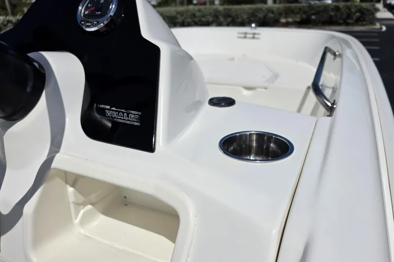 Slide: The Image of 2012 Boston Whaler 15 Super Sport dashboard with cup holder and steering wheel. - 8