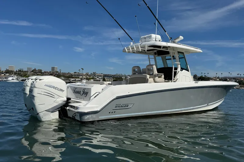 The Image of 2019 Boston Whaler 330 Outrage boat on calm water, featuring twin Mercury engines. - 0