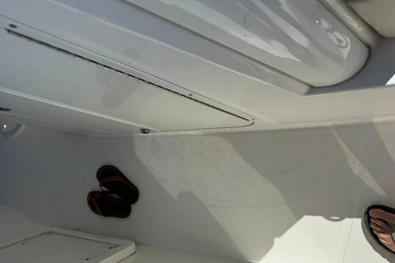 Slide: The Image of Interior of a 2019 Boston Whaler 330 Outrage boat with sandals on the floor. - 19