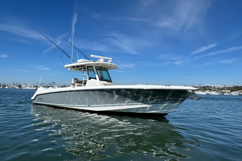 Slide: The Image of 2019 Boston Whaler 330 Outrage boat on calm water under clear blue sky. - 20