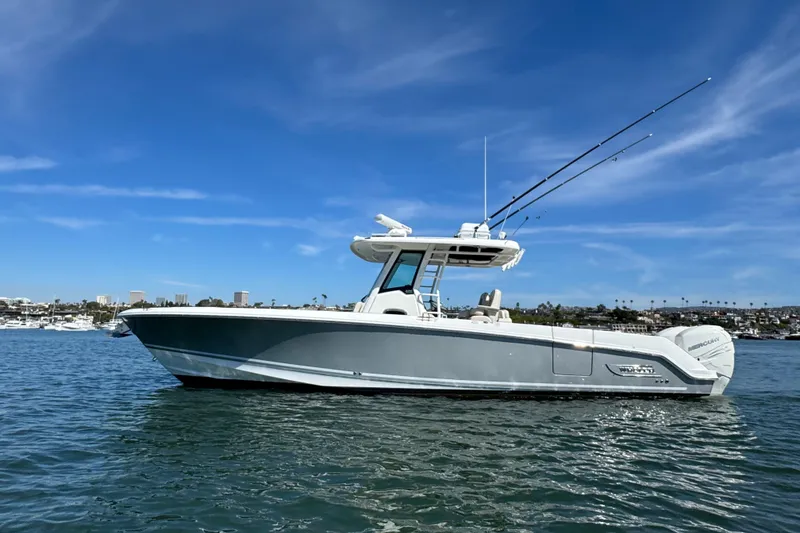 Slide: The Image of 2019 Boston Whaler 330 Outrage boat on calm water under clear blue sky. - 21