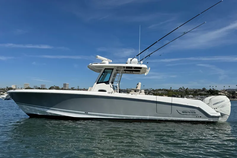 Slide: The Image of 2019 Boston Whaler 330 Outrage boat on calm water under clear blue sky. - 22
