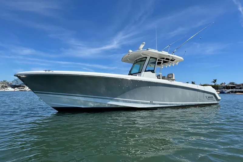 Slide: The Image of 2019 Boston Whaler 330 Outrage boat on calm water under clear blue sky. - 23