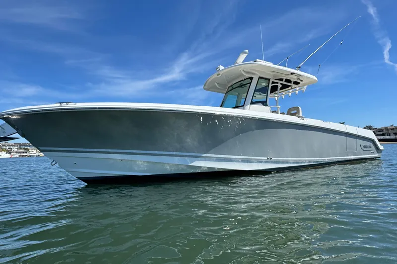 Slide: The Image of 2019 Boston Whaler 330 Outrage boat on water under clear blue sky. - 24