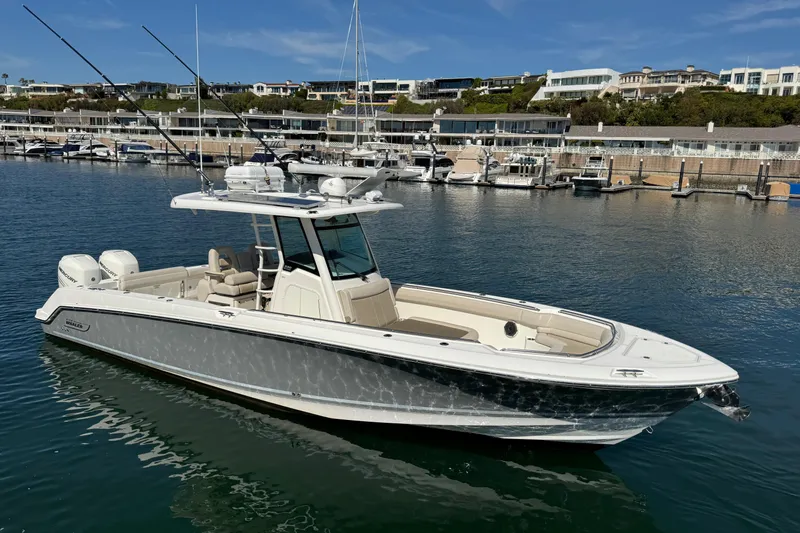 Slide: The Image of 2019 Boston Whaler 330 Outrage boat docked in marina, clear sky background. - 6