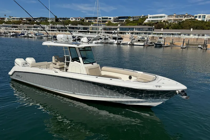 Slide: The Image of 2019 Boston Whaler 330 Outrage boat docked in a marina, showcasing sleek design and luxury features. - 7
