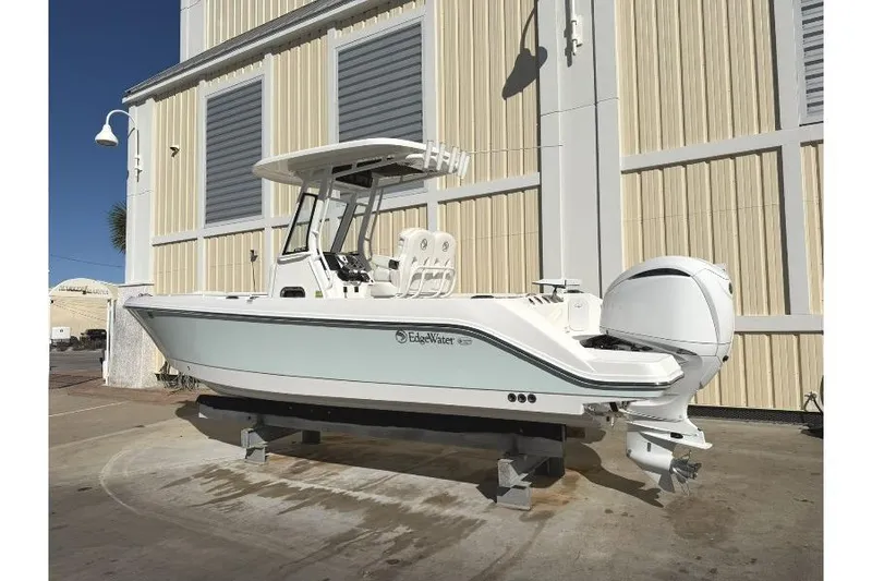 Slide: The Image of 2023 Edgewater 230CC boat displayed outdoors, featuring sleek design and modern outboard motor. - 2