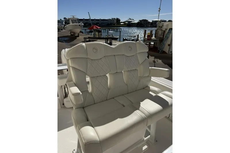 Slide: The Image of Luxurious seating on 2023 Edgewater 230CC boat, docked by a scenic waterfront. - 8