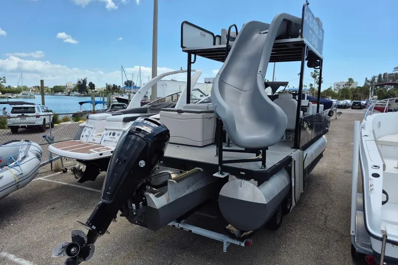 Slide: The Image of 2022 Sport Pontoons Tritoon Slide with outboard motor and water slide, docked at marina. - 5