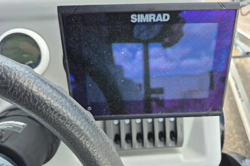 Slide: The Image of Steering wheel and Simrad display on 2022 Sport Pontoons Tritoon Slide boat. - 15