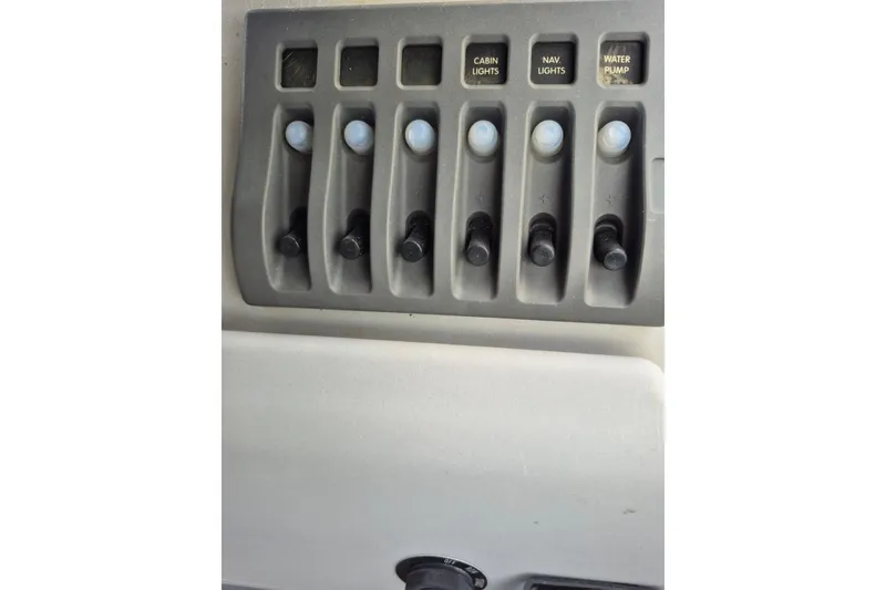 Slide: The Image of Control panel of 2022 Sport Pontoons Tritoon Slide with labeled switches for lights and water pump. - 16