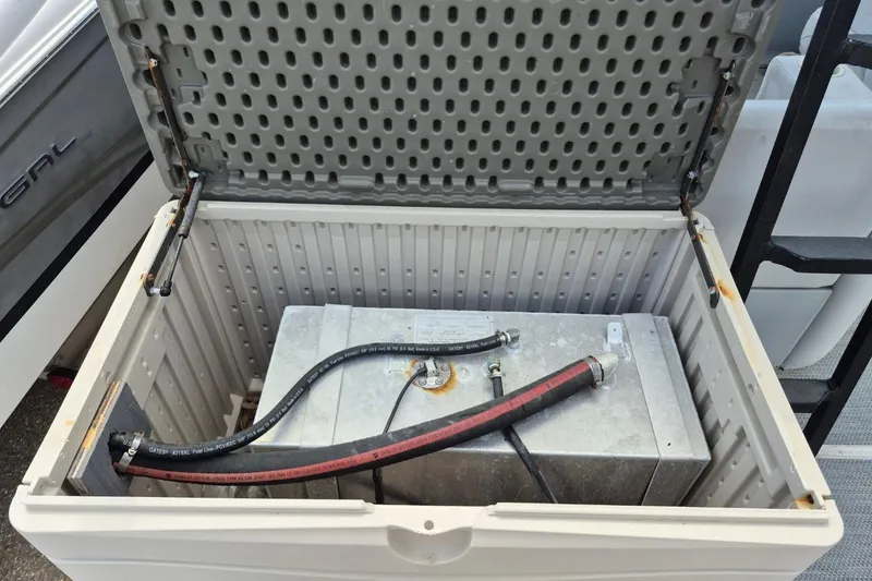 Slide: The Image of Open storage compartment of 2022 Sport Pontoons Tritoon Slide, revealing internal components and hoses. - 9