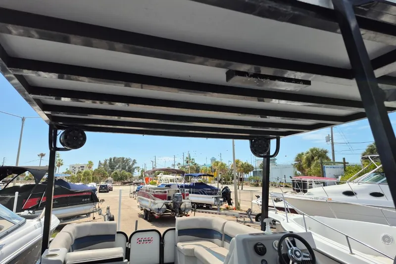Slide: The Image of 2022 Sport Pontoons Tritoon Slide with upper deck, docked among other boats. - 11