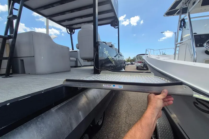 Slide: The Image of 2022 Sport Pontoons Tritoon Slide with deck and seating, shown in a marina setting. - 4