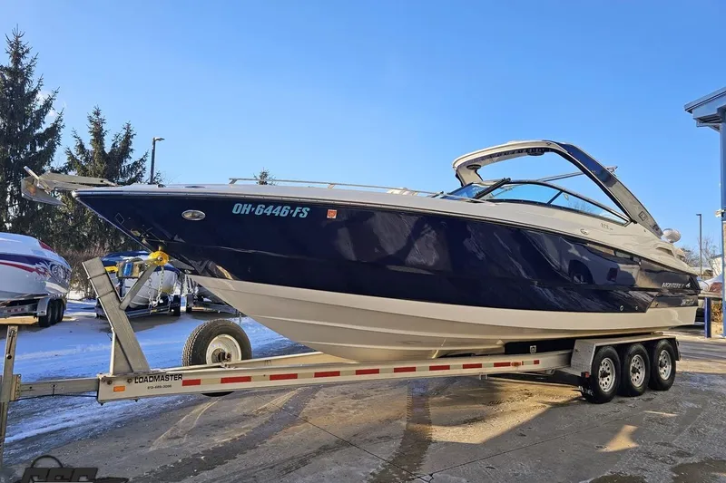 Slide: The Image of 2011 Monterey 328SS Super Sport boat on trailer, parked outdoors under clear blue sky. - 10