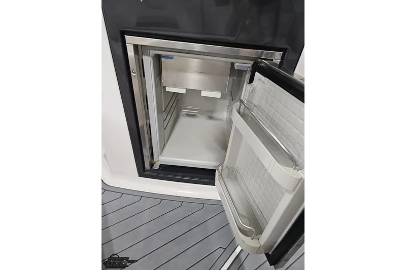 Slide: The Image of Open refrigerator on 2011 Monterey 328SS Super Sport boat, showcasing interior storage space. - 43
