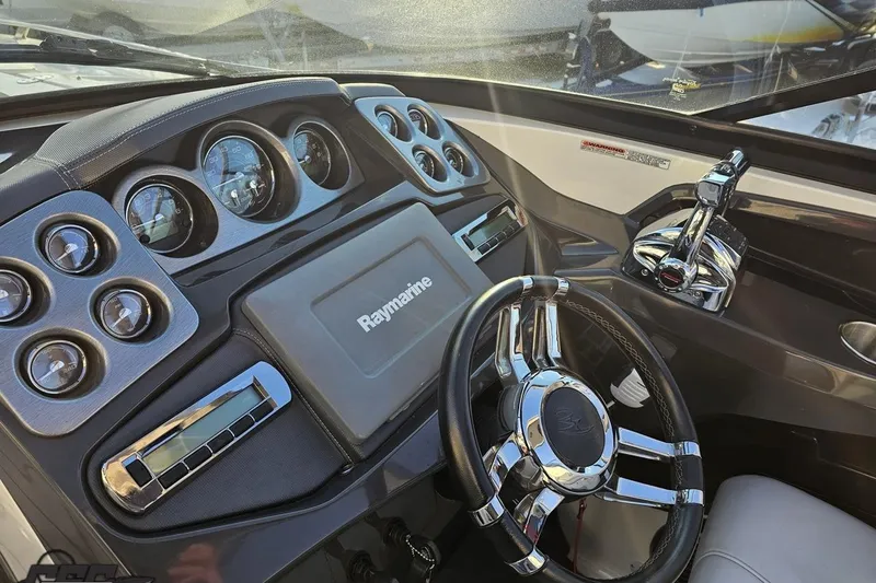 Slide: The Image of Dashboard of a 2011 Monterey 328SS Super Sport boat with steering wheel and controls. - 54