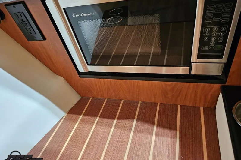 Slide: The Image of Microwave in 2011 Monterey 328SS Super Sport boat interior with wood paneling. - 71