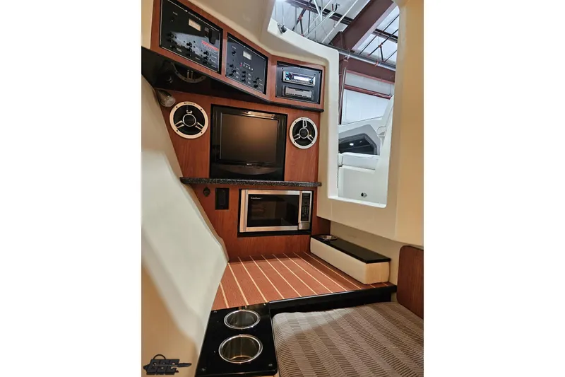 Slide: The Image of Interior of 2011 Monterey 328SS Super Sport boat with entertainment system and wood accents. - 76