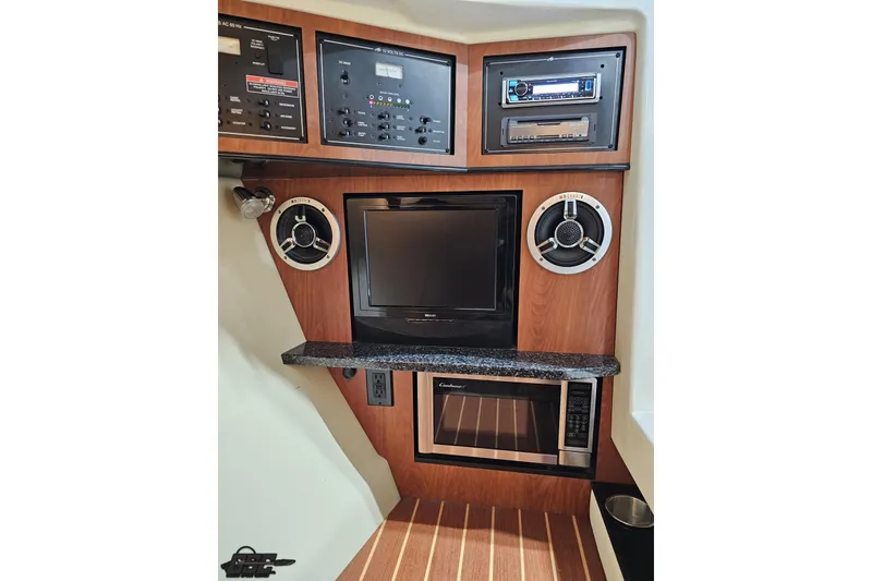 Slide: The Image of Interior of 2011 Monterey 328SS Super Sport with control panel, speakers, TV, and microwave. - 77