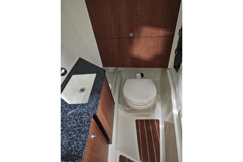 Slide: The Image of 2011 Monterey 328SS Super Sport boat bathroom with sink, toilet, and wooden cabinetry. - 81