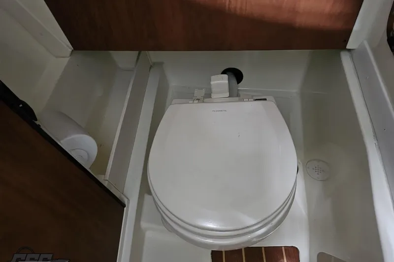 Slide: The Image of 2011 Monterey 328SS Super Sport boat bathroom with compact toilet and wooden accents. - 83