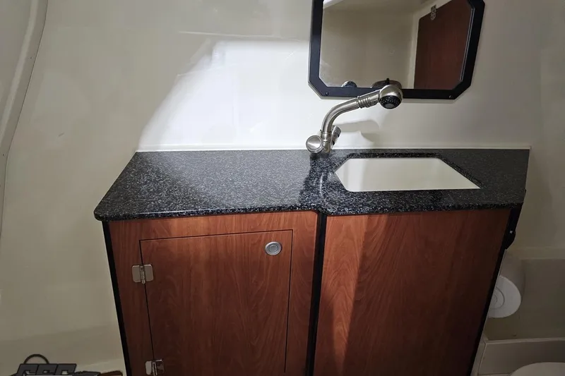 Slide: The Image of 2011 Monterey 328SS Super Sport bathroom with granite countertop and wooden cabinet. - 84