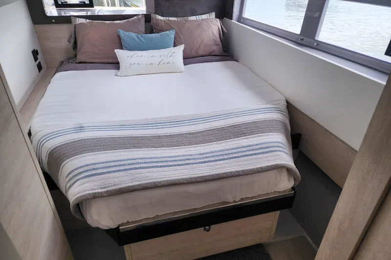 Slide: The Image of Cozy bedroom in a 2020 Leopard 45 yacht with striped bedding and decorative pillows. - 102