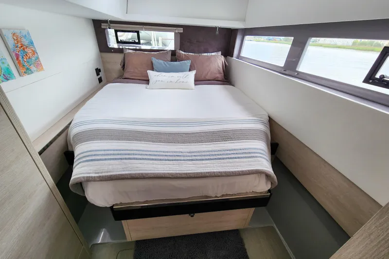 Slide: The Image of Cozy bedroom interior on a 2020 Leopard 45 yacht with striped bedding and scenic window views. - 103
