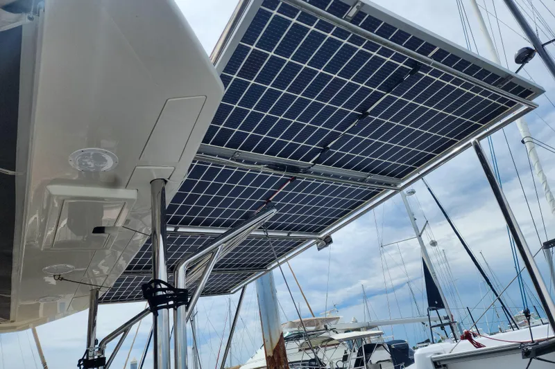 Slide: The Image of Solar panels on a 2020 Leopard 45 catamaran, docked at a marina under a cloudy sky. - 12